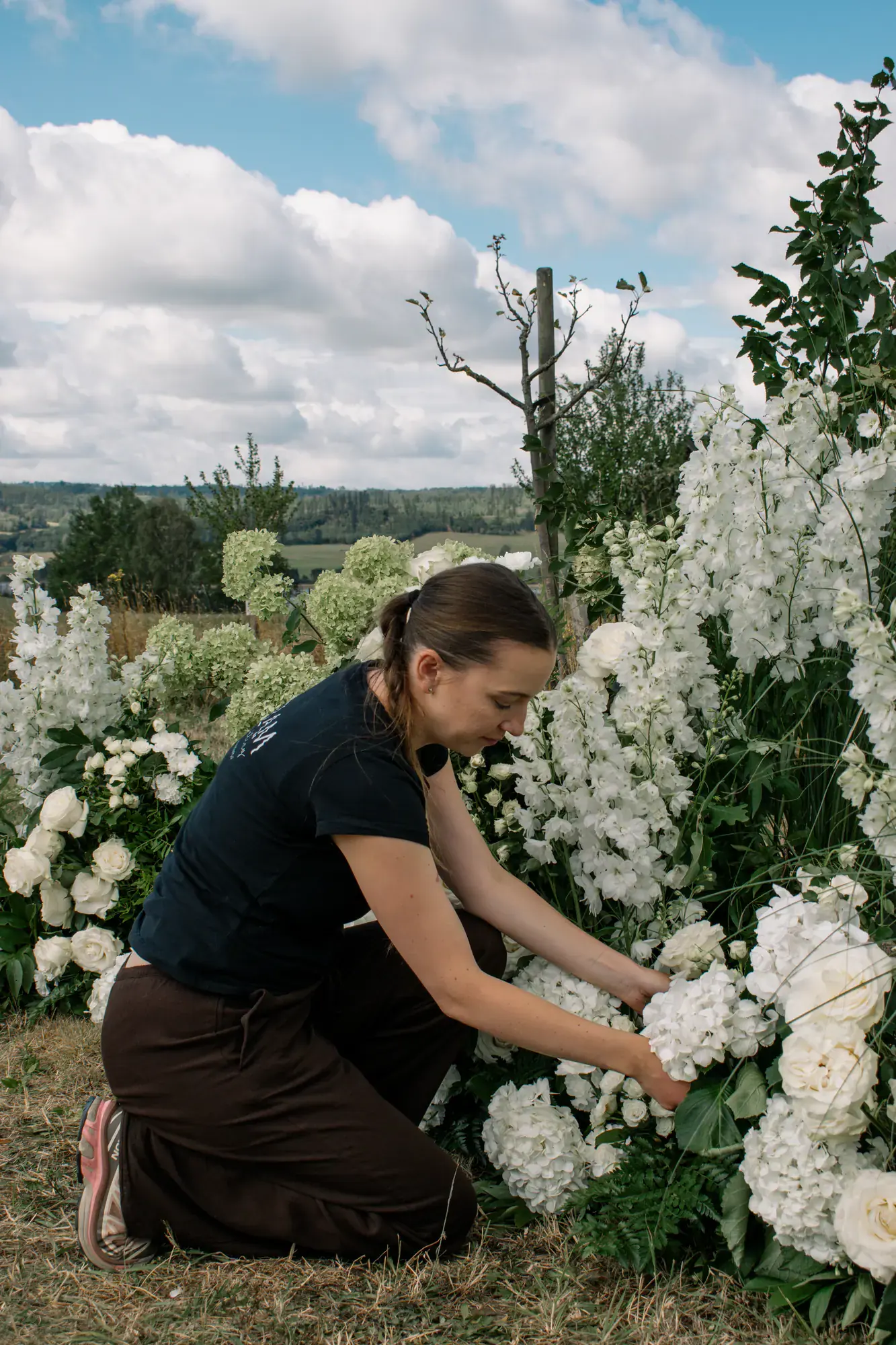 Floristka připravuje květiny na venkovní svatbě